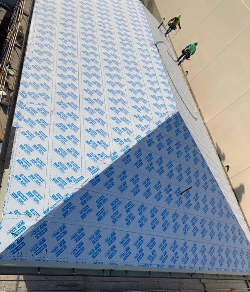 Professional roofers installing underlayment on a metal roof in Clarkson